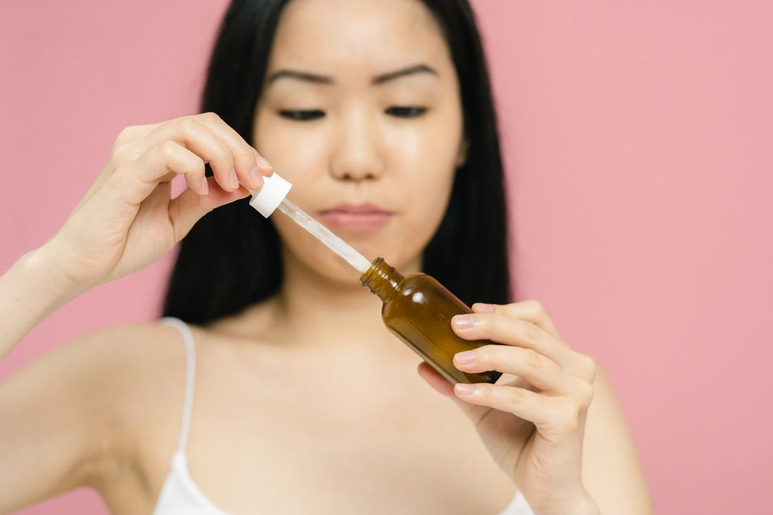 Mujer aplicando sérum con gotero en piel luminosa — rutina glass skin coreana