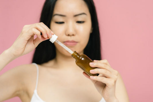 Mujer aplicando sérum con gotero en piel luminosa — rutina glass skin coreana